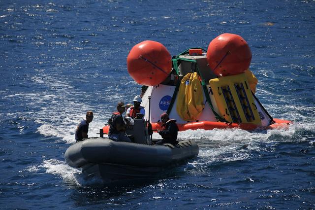 Recovery team members move away from a test version of Orion ready to be recovered from the Pacific Ocean on Sept. 13, 2014. A combined NASA and U.S. Navy team practiced recovery techniques off the coast of California over the course of the the week -- first with a crane on board the Navy's USS Salvor, then using the USS Anchorage's well deck -- in preparation for Exploration Flight Test-1 (EFT-1). Part of Batch image transfer from Flickr.