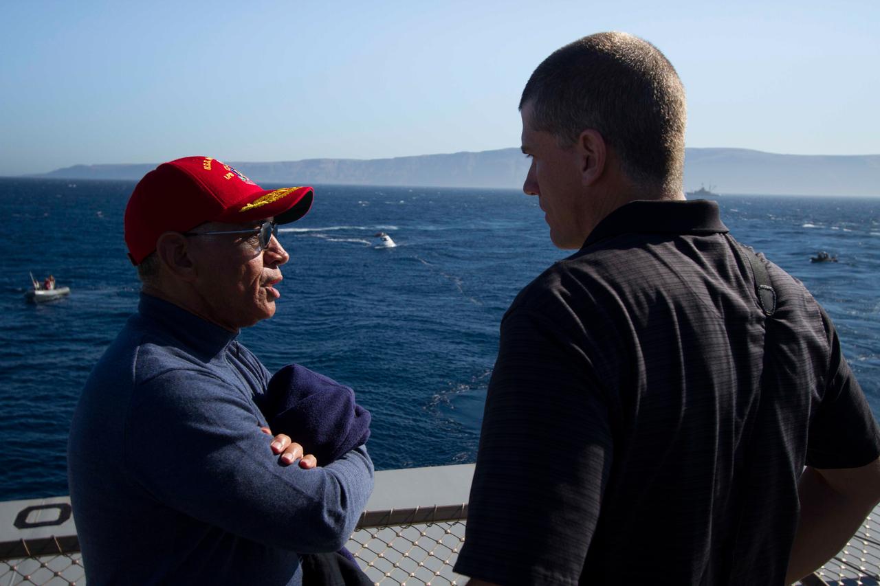 NASA Administrator Charles Bolden talks with a member of the Orion recovery team on board the USS Anchorage as a test version of Orion is reeled into the Anchorage's well deck in the background on Sept. 15, 2014.  Part of Batch image transfer from Flickr.
