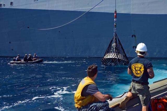 Recovery team members work to lift a test version of Orion's forward bay cover out of the Pacific Ocean using a crane on board the USS Anchorage on Sept. 16, 2014. NASA and the Navy are working together this week to test tools and techniques that will be used to retrieve the spacecraft once it splashes down following Exploration Flight Test-1 (EFT-1). The forward bay cover protects the top section of Orion's crew module until the spacecraft is almost ready to land. It is jettisoned to allow Orion's parachutes to deploy and must be recovered separately from the crew module.  Part of Batch image transfer from Flickr.