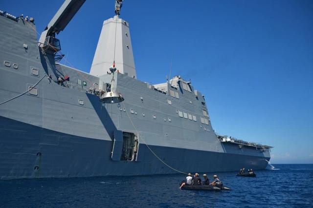 Recovery team members work to lift a test version of Orion's forward bay cover out of the Pacific Ocean using a crane on board the USS Anchorage on Sept. 16, 2014. NASA and the Navy are working together this week to test tools and techniques that will be used to retrieve the spacecraft once it splashes down following Exploration Flight Test-1 (EFT-1). The forward bay cover protects the top section of Orion's crew module until the spacecraft is almost ready to land. It is jettisoned to allow Orion's parachutes to deploy and must be recovered separately from the crew module.  Part of Batch image transfer from Flickr.