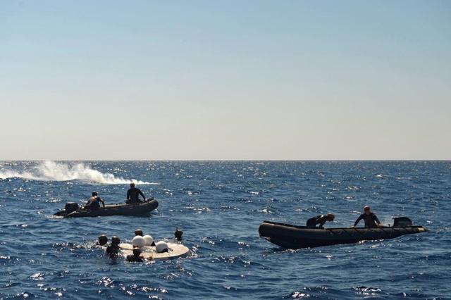 Recovery team members work to retrieve a test version of Orion's forward bay cover from the Pacific Ocean on Sept. 16, 2014. NASA and the Navy are working together this week to test tools and techniques that will be used to recover the spacecraft once it splashes down following Exploration Flight Test-1 (EFT-1). The forward bay cover protects the top section of Orion's crew module until the spacecraft is almost ready to land. It is jettisoned to allow Orion's parachutes to deploy and must be recovered separately from the crew module.  Part of Batch image transfer from Flickr.