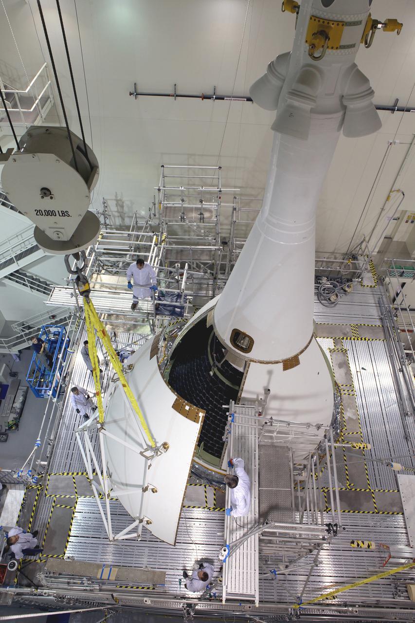 The last major assembly operation to prepare Orion for Exploration Flight Test-1 (EFT-1) is completed in the Launch Abort System Facility (LASF) at Kennedy Space Center on Oct. 11, 2014. The ogive panels, which protect the crew module from sound and vibration during ascent, were installed around the spacecraft just below the launch abort system tower. Part of Batch image transfer from Flickr.