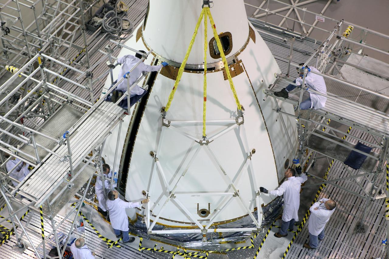 The last major assembly operation to prepare Orion for Exploration Flight Test-1 (EFT-1) is completed in the Launch Abort System Facility (LASF) at Kennedy Space Center on Oct. 11, 2014. The ogive panels, which protect the crew module from sound and vibration during ascent, were installed around the spacecraft just below the launch abort system tower. Part of Batch image transfer from Flickr.