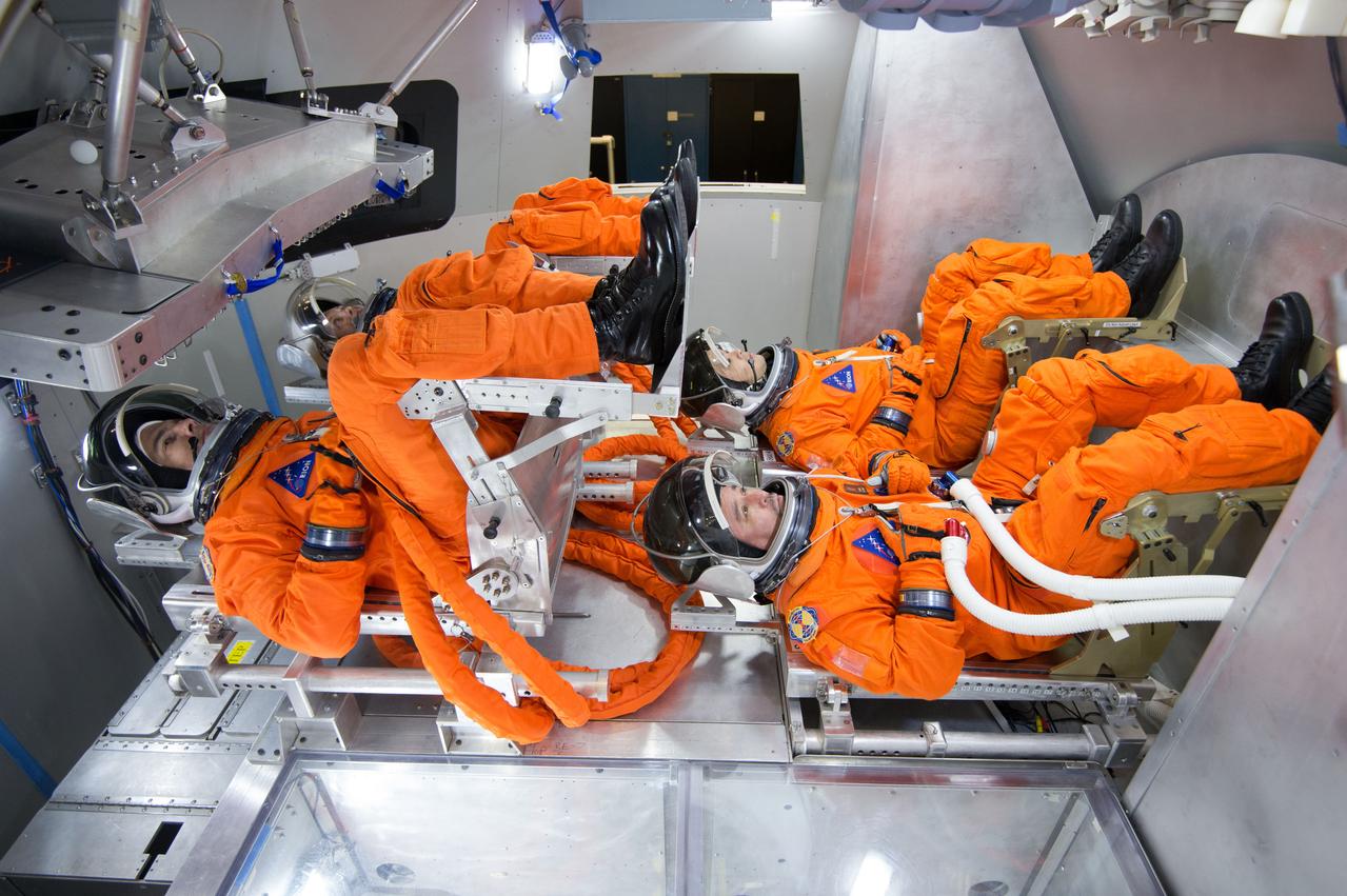 Spacesuit engineers demonstrate how four crew members would be arranged for launch inside the Orion spacecraft, using a mockup of the vehicle at Johnson Space Center in Houston on Oct. 24, 2014.  Part of Batch image transfer from Flickr.