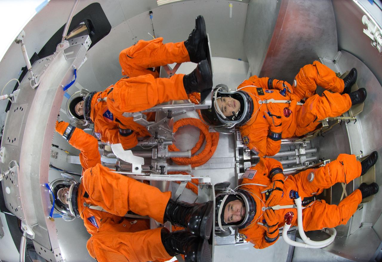 Spacesuit engineers demonstrate how four crew members would be arranged for launch inside the Orion spacecraft, using a mockup of the vehicle at Johnson Space Center in Houston on Oct. 24, 2014.  Part of Batch image transfer from Flickr.