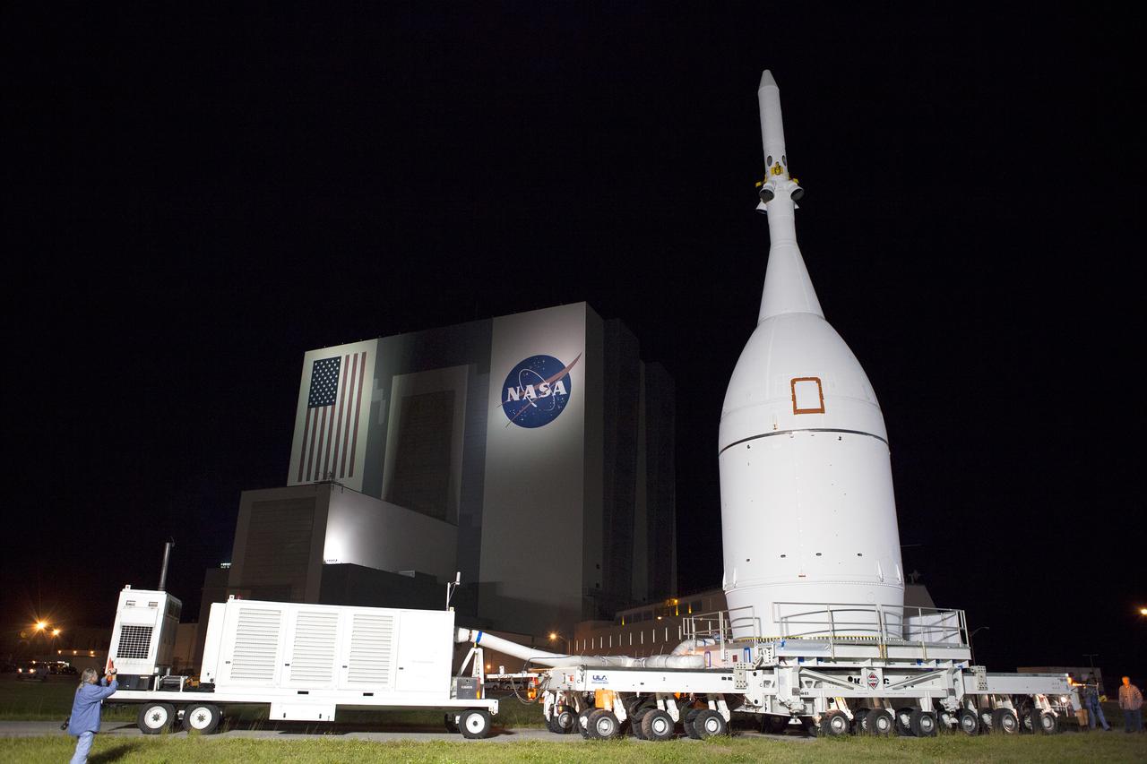 At NASA's Kennedy Space Center in Florida, the agency's Orion spacecraft pauses in front of the spaceport's iconic Vehicle Assembly Building as it is transported to Launch Complex 37 at Cape Canaveral Air Force Station on Nov. 11, 2014. After arrival at the launch pad, United Launch Alliance engineers and technicians lifted Orion and mounted it atop its Delta IV Heavy rocket. Part of Batch image transfer from Flickr.