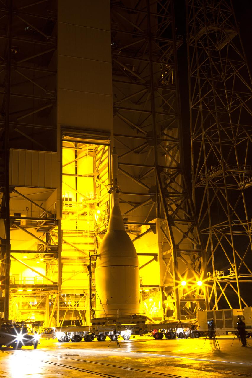 The Orion spacecraft and its transporter stand at the base of the service structure at Space Launch Complex 37 on Nov. 12, 2014. A crane inside the structure will lift Orion off its transporter to hoist it into place atop the Delta IV Heavy rocket that is already assembled at the pad.  Part of Batch image transfer from Flickr.