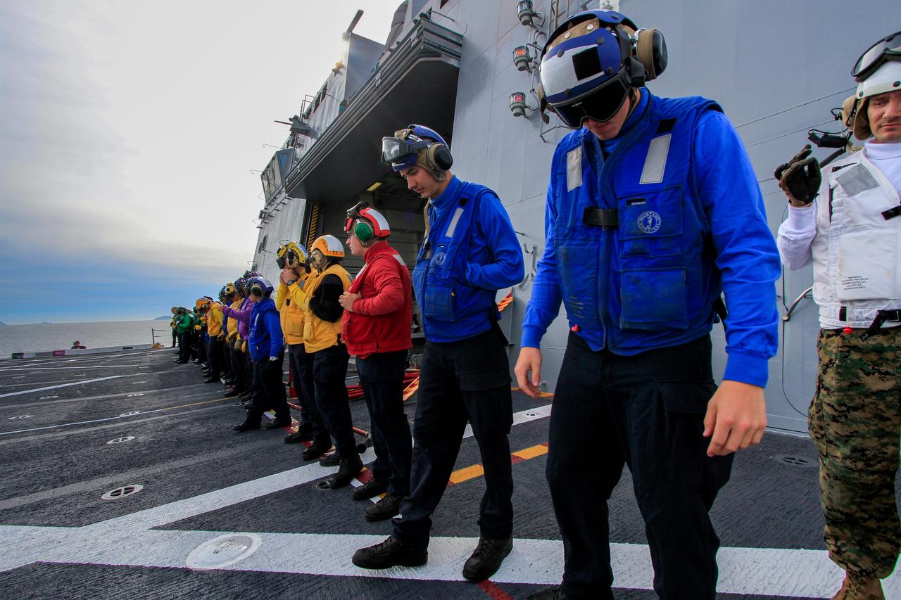 Recovery team members inspect the flight deck of the U.S. Navy's USS Anchorage as the Anchorage is make its way to the Orion recovery zone on Dec. 1, 2014. Orion is scheduled to launch on Exploration Flight Test-1 (EFT-1) from Florida on Dec. 4, and splashdown 4.5 hours later in the Pacific Ocean, where it will be picked up by the Anchorage.  Part of Batch image transfer from Flickr.