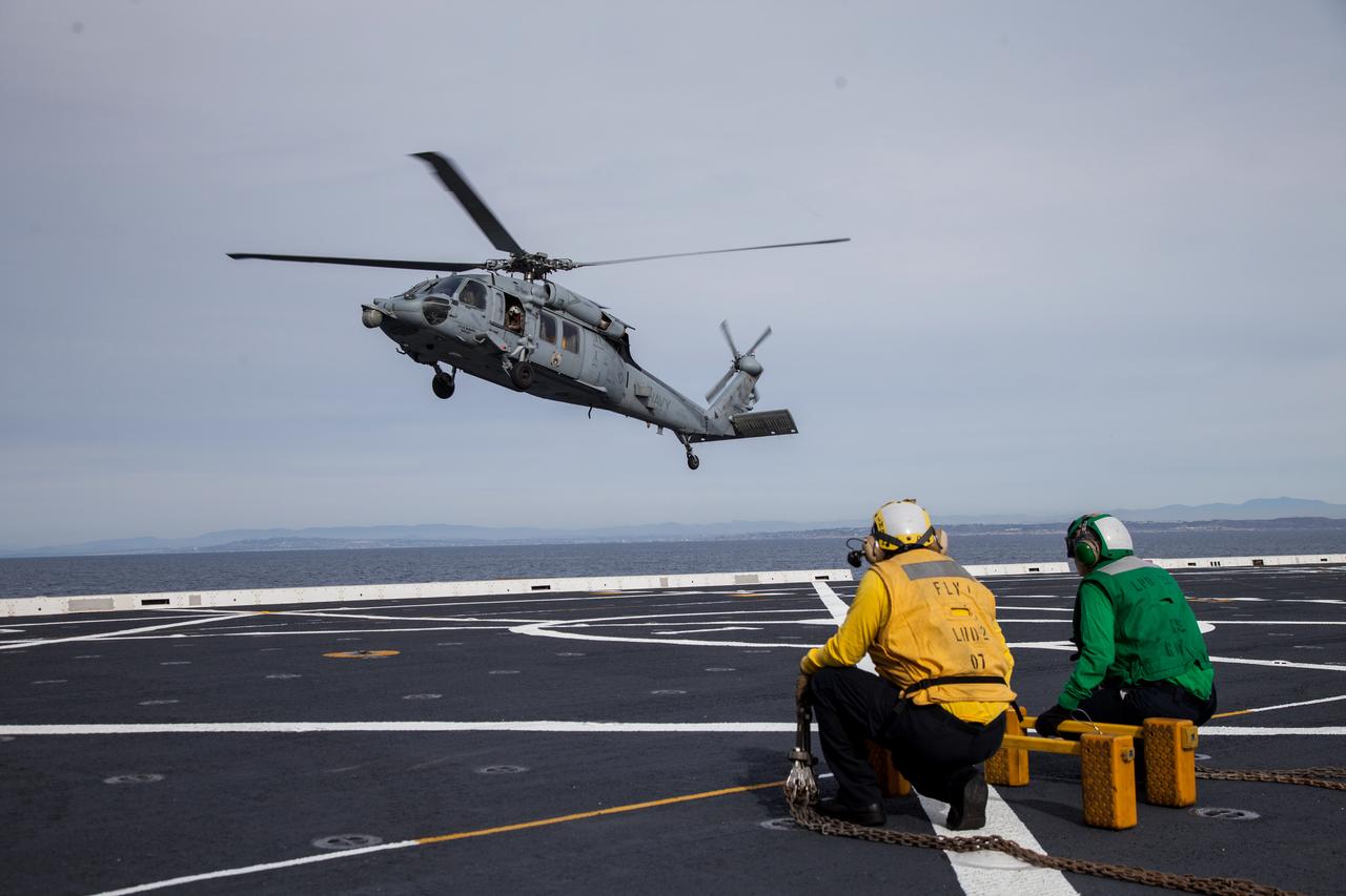A helicopter lands on the flight deck of the USS Anchorage as the Navy ship makes its way to the recovery zone for NASA's Orion spacecraft on Dec. 1, 2014. Orion is scheduled to launch on Exploration Flight Test-1 (EFT-1) from Florida on Dec. 4, and splashdown 4.5 hours later in the Pacific Ocean, where it will be picked up by the Anchorage. Part of Batch image transfer from Flickr.