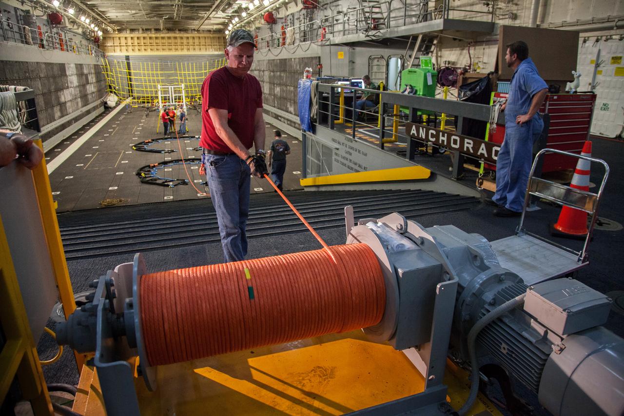 Orion recovery team members make preparations for Orion's splashdown inside the well deck of the U.S. Navy's USS Anchorage Dec. 2, 2014. A combined NASA/Navy team will tow Orion into the Anchorage's flooded well deck using the orange line after the spacecraft lands in the Pacific Ocean following Exploration Flight Test-1 (EFT-1) on Dec. 4. Part of Batch image transfer from Flickr.