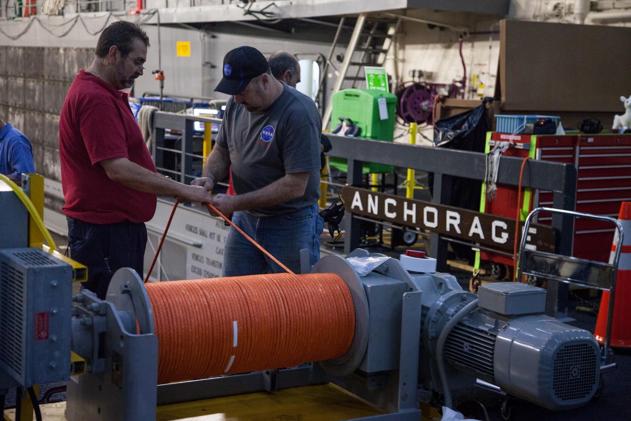 Orion recovery team members make preparations for Orion's splashdown inside the well deck of the U.S. Navy's USS Anchorage on Dec. 2, 2014. A combined NASA/Navy team will tow Orion into the Anchorage's flooded well deck using the orange line after the spacecraft lands in the Pacific Ocean following Exploration Flight Test-1 (EFT-1) on Dec. 4. Part of Batch image transfer from Flickr.
