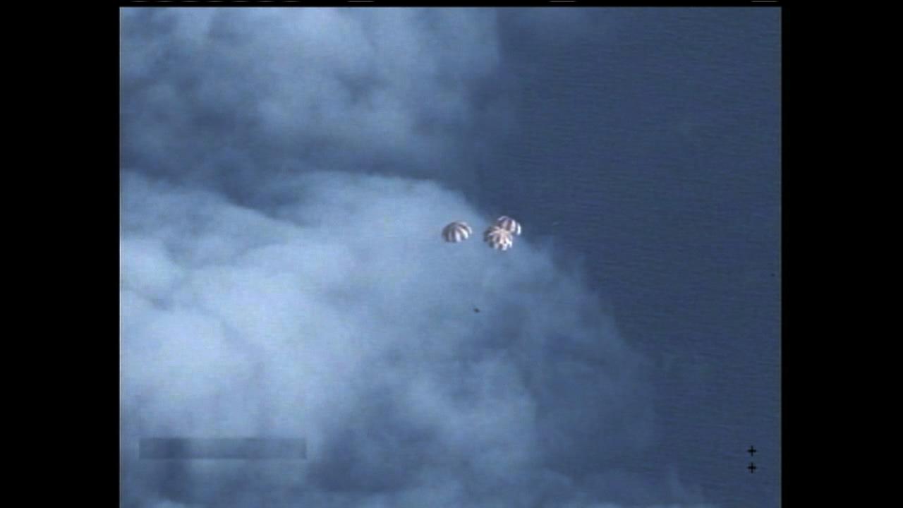Following more than four hours in Earth orbit, NASA's Orion spacecraft is seen from an unpiloted aircraft as it descends under three massive red and white main parachutes after Exploration Flight Test-1 (EFT-1) on Dec. 5, 2014. Splashdown in the Pacific Ocean will take place at less than 20 mph. It will be recovered by the USS Anchorage, a landing platform-dock, or LPD, ship.  Part of Batch image transfer from Flickr.