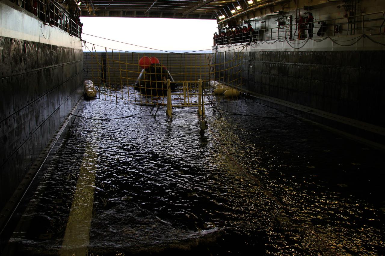 NASA’s Orion spacecraft is pulled safely into the well deck of the U.S. Navy’s USS Anchorage, following its splashdown in the Pacific Ocean. Orion launched into space on a two-orbit, 4.5-test flight at 7:05 am EST on Dec. 5, and returned safely to Earth, where a combined team from NASA, the Navy and Orion prime contractor Lockheed Martin retrieved it for return to shore. Over the next several days, the team will perform an initial check out of Orion while the Anchorage transports the spacecraft back to shore. It is expected to be off loaded at Naval Base San Diego on Monday. Part of Batch image transfer from Flickr.