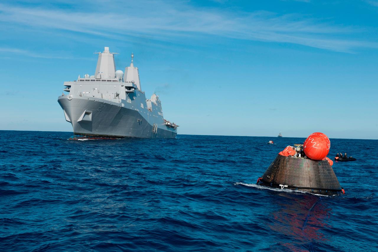 The U.S. Navy's USS Anchorage moves into place to recover NASA's Orion spacecraft following its splashdown in the Pacific Ocean. Orion launched into space on a two-orbit, 4.5-test flight at 7:05 am EST on Dec. 5, and returned safely to Earth, where a combined team from NASA, the Navy and Orion prime contractor Lockheed Martin retrieved it for return to shore. It's now being transported back to shore on board the Anchorage. It is expected to be off loaded at Naval Base San Diego on Monday.  Part of Batch image transfer from Flickr.