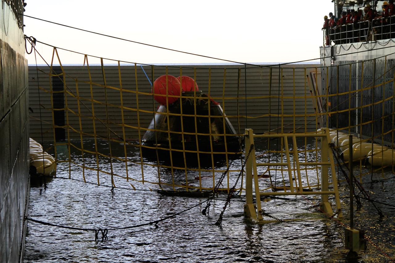 NASA’s Orion spacecraft is pulled safely into the well deck of the U.S. Navy’s USS Anchorage, following its splashdown in the Pacific Ocean. Orion launched into space on a two-orbit, 4.5-test flight at 7:05 am EST on Dec. 5, and returned safely to Earth, where a combined team from NASA, the Navy and Orion prime contractor Lockheed Martin retrieved it for return to shore. Over the next several days, the team will perform an initial check out of Orion while the Anchorage transports the spacecraft back to shore. It is expected to be off loaded at Naval Base San Diego on Monday. Part of Batch image transfer from Flickr.