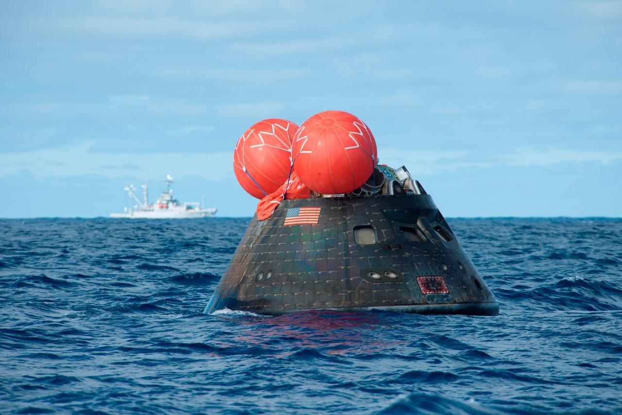 NASA's Orion spacecraft awaits the U.S. Navy's USS Anchorage for a ride home. Orion launched into space on a two-orbit, 4.5-test flight at 7:05 am EST on Dec. 5, and returned safely splashed down in the Pacific Ocean, where a combined team from NASA, the Navy and Orion prime contractor Lockheed Martin retrieved it for return to shore. It's now being transported back to shore on board the Anchorage. It is expected to be off loaded at Naval Base San Diego on Monday. Part of Batch image transfer from Flickr.