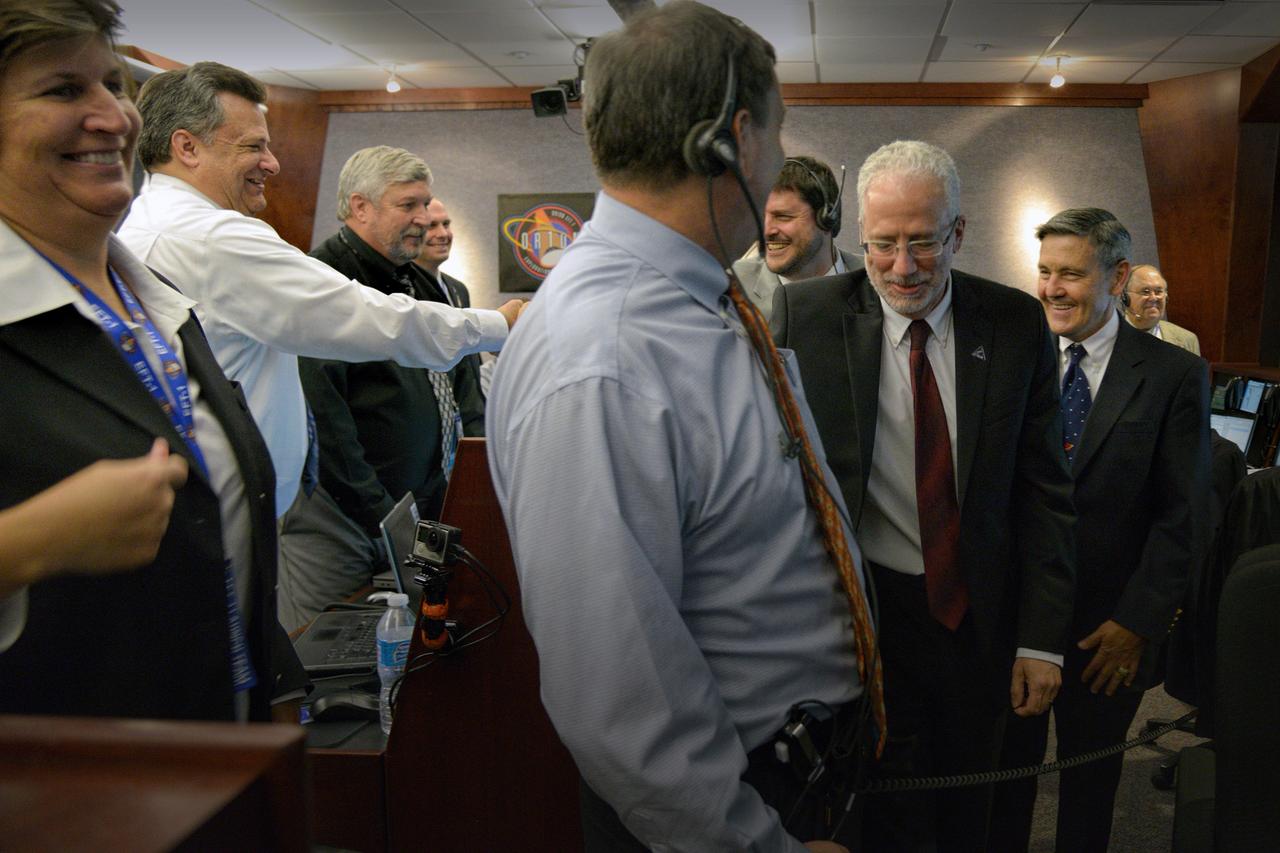 The Orion team celebrates Orion's successful Exploration Flight Test-1 (EFT-1) mission in Building AE at Cape Canaveral Air Force Station on Dec. 5, 2014. The Orion spacecraft orbited Earth twice, reaching an altitude of approximately 3,600 miles above Earth before landing. No one was aboard Orion for this flight test, but the spacecraft is designed to allow us to journey to destinations never before visited by humans, including an asteroid and Mars. Part of Batch image transfer from Flickr.