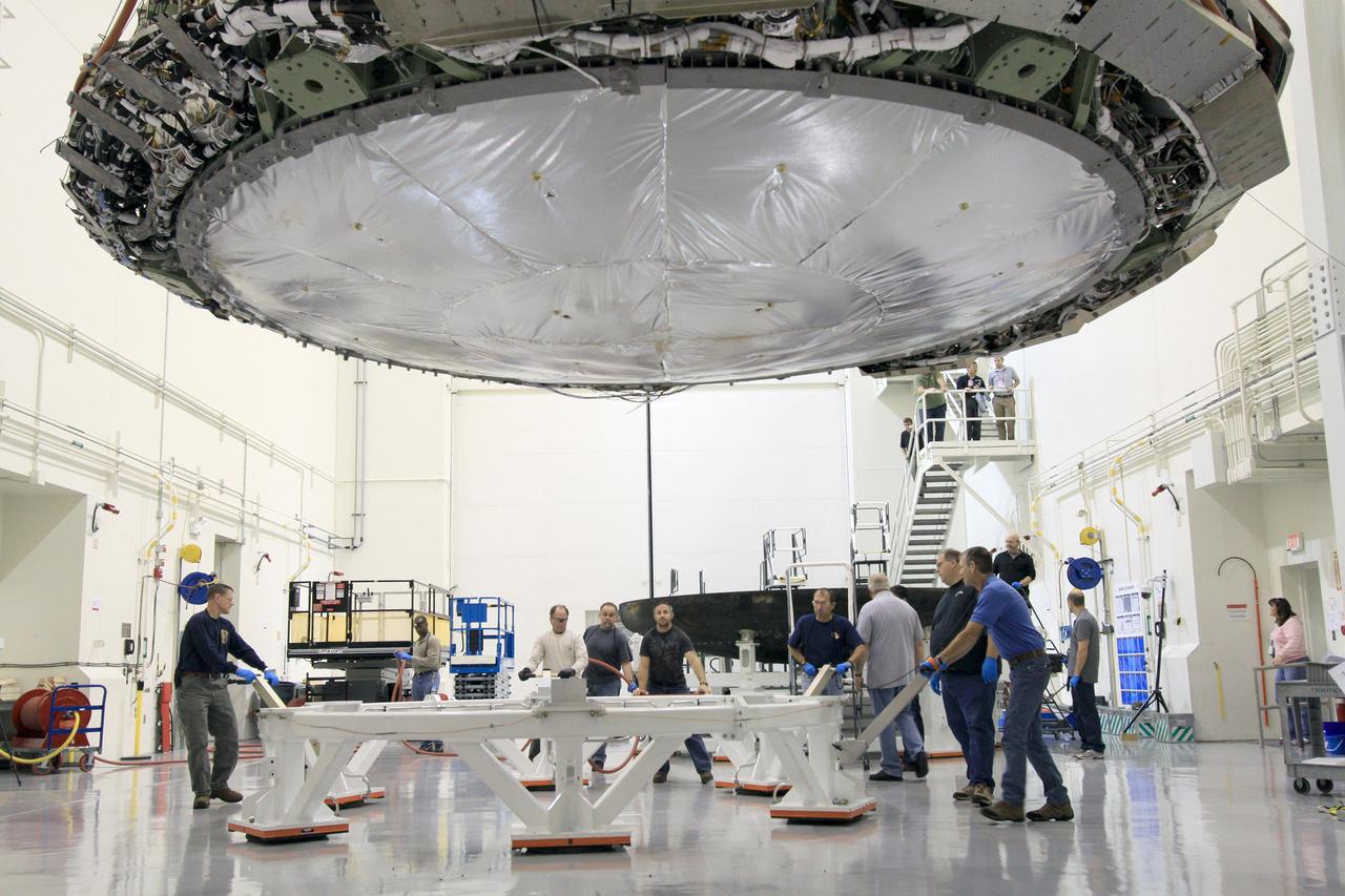 On Feb. 13, 2015, Lockheed Martin engineers remove the heat shield from the Orion vehicle that flew on Exploration Flight Test-1 (EFT-1) in December 2014 in Operations and Checkout Building (O&amp;C) at Kennedy Space Center. The heat shield will be transported to the Marshall Space Flight Center for testing. Part of Batch image transfer from Flickr.