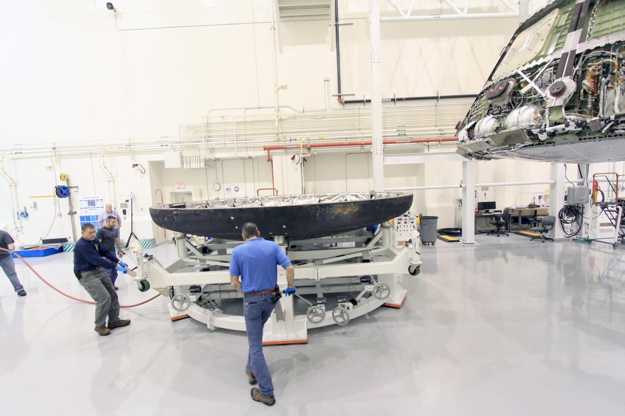 On Feb. 13, 2015, Lockheed Martin engineers remove the heat shield from the Orion vehicle that flew on Exploration Flight Test-1 (EFT-1) in December 2014 in Operations and Checkout Building (O&amp;C) at Kennedy Space Center. The heat shield will be transported to the Marshall Space Flight Center for testing. Part of Batch image transfer from Flickr.