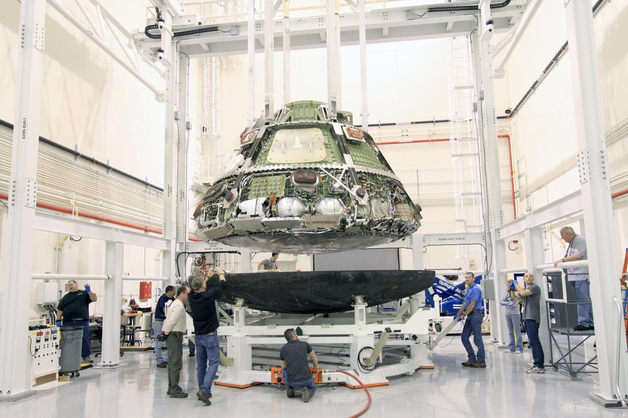 On Feb. 13, 2015, Lockheed Martin engineers remove the heat shield from the Orion vehicle that flew on Exploration Flight Test-1 (EFT-1) in December 2014 in Operations and Checkout Building (O&amp;C) at Kennedy Space Center. The heat shield will be transported to the Marshall Space Flight Center for testing. Part of Batch image transfer from Flickr.