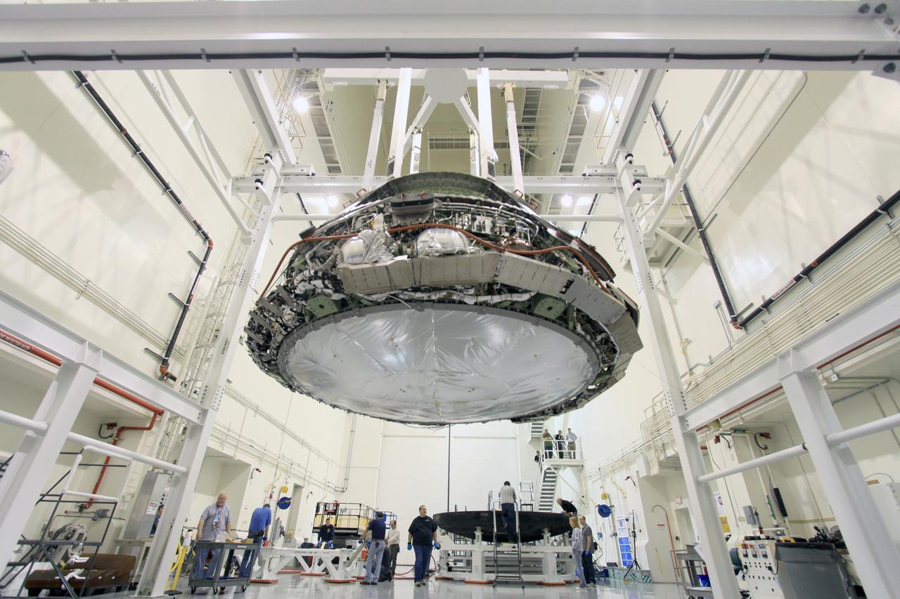 On Feb. 13, 2015, Lockheed Martin engineers remove the heat shield from the Orion vehicle that flew on Exploration Flight Test-1 (EFT-1) in December 2014 in Operations and Checkout Building (O&amp;C) at Kennedy Space Center. The heat shield will be transported to the Marshall Space Flight Center for testing. Part of Batch image transfer from Flickr.