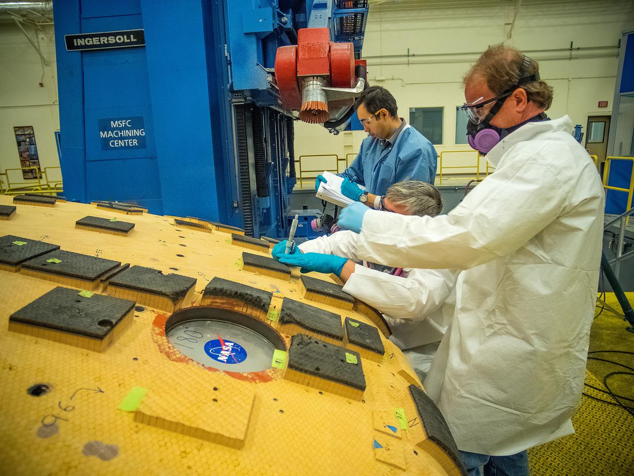 Engineers from NASA's Ames Research Center at Moffett Field, California, and Marshall Space Flight Center in Huntsville, Alabama, remove samples on May 4, 2015, from Orion's heat shield which flew on Exploration Flight Test-1 (EFT-1) in 2014. The heat shield protected the spacecraft from temperatures reaching 4000 degrees F. Part of Batch image transfer from Flickr.