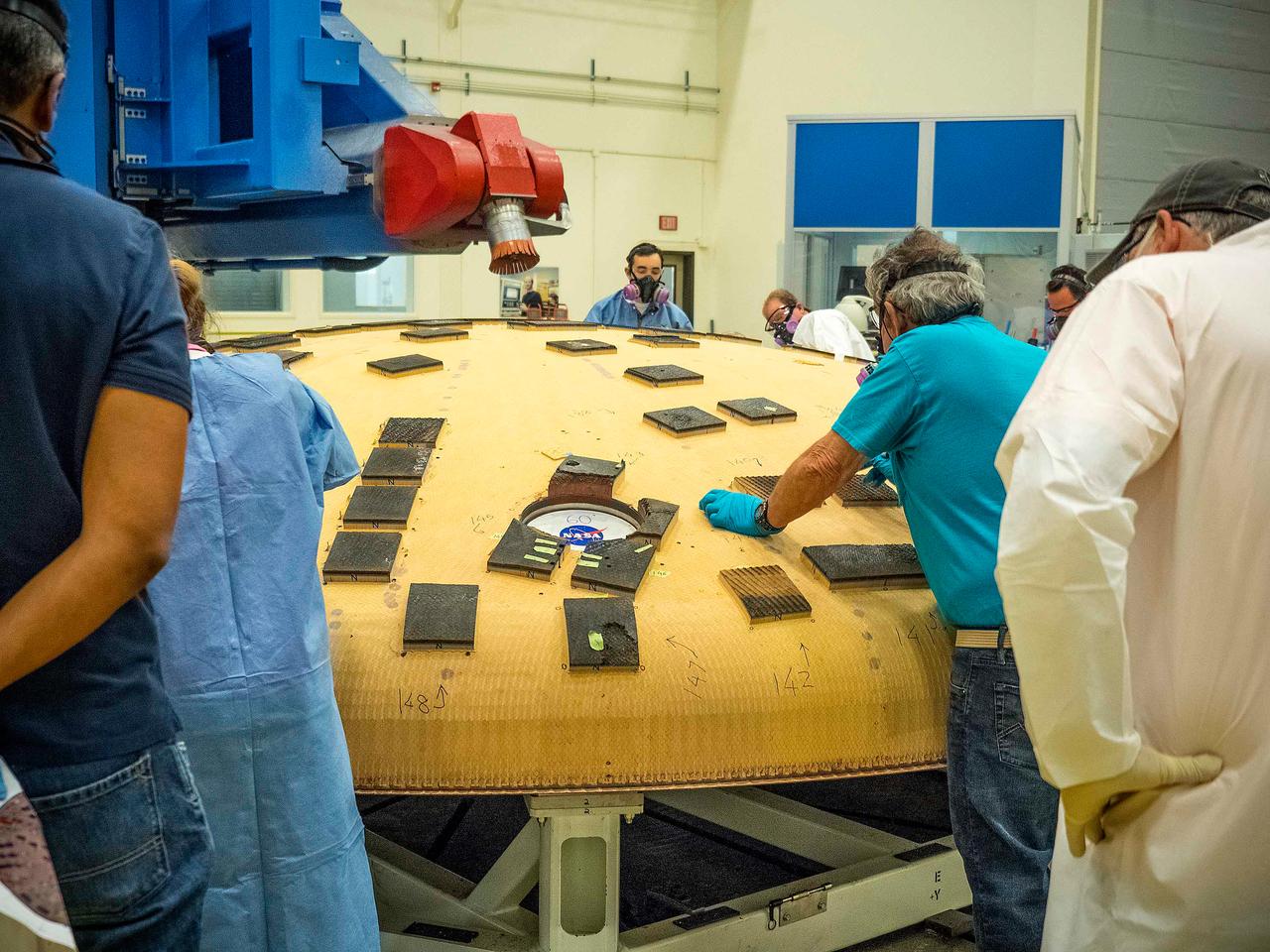 Engineers from NASA's Ames Research Center at Moffett Field, California, and Marshall Space Flight Center in Huntsville, Alabama, remove samples on May 4, 2015, from Orion's heat shield which flew on Exploration Flight Test-1 (EFT-1) in 2014. The heat shield protected the spacecraft from temperatures reaching 4000 degrees F. Part of Batch image transfer from Flickr.