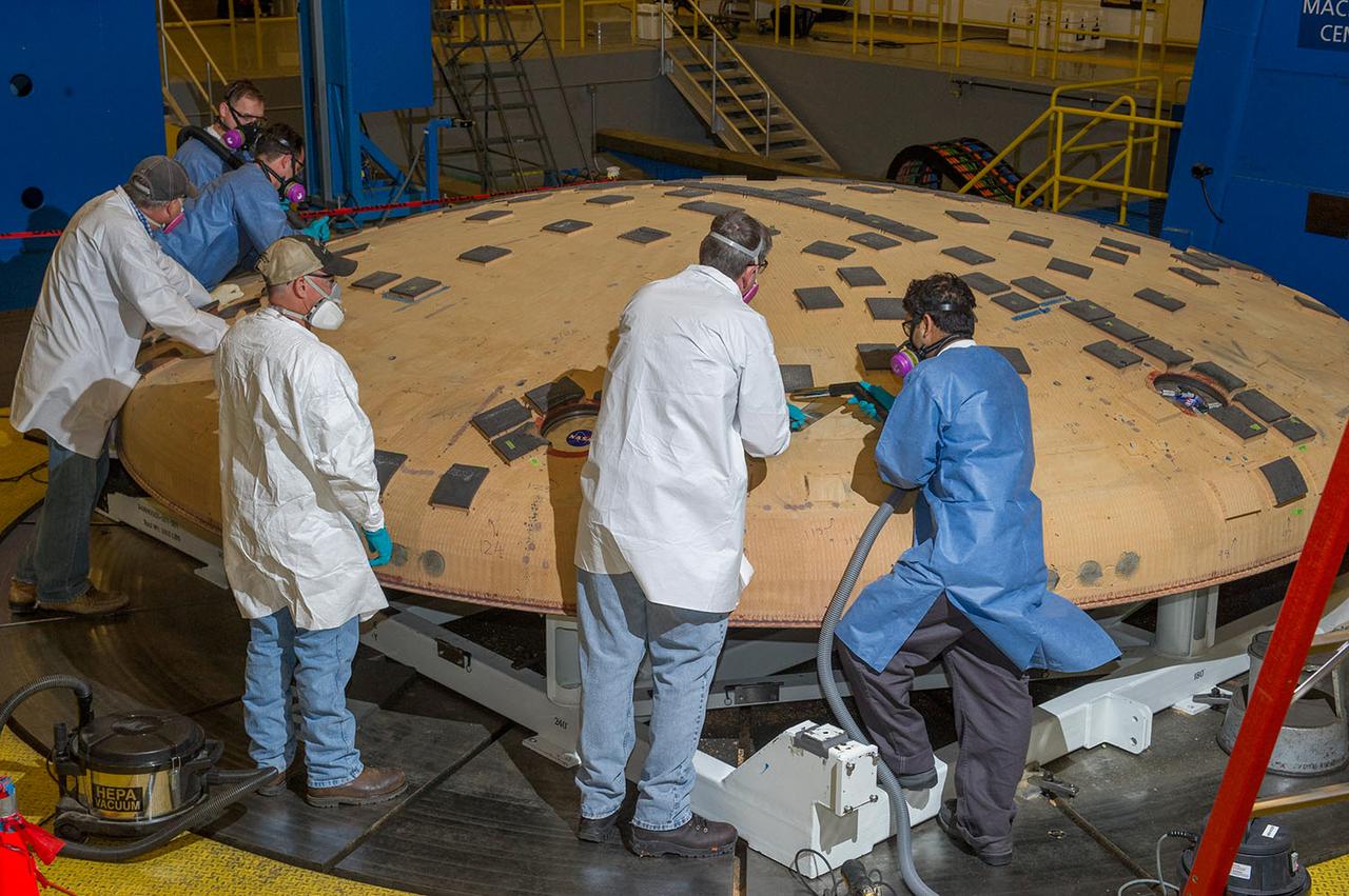Engineers from NASA's Ames Research Center at Moffett Field, California, and Marshall Space Flight Center in Huntsville, Alabama, remove samples on May 4, 2015, from Orion's heat shield which flew on Exploration Flight Test-1 (EFT-1) in 2014. The heat shield protected the spacecraft from temperatures reaching 4000 degrees F. Part of Batch image transfer from Flickr.