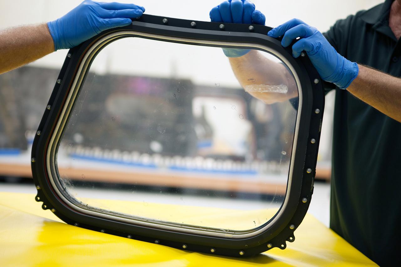 Inside the Neil Armstrong Operations and Checkout Building high bay at NASA's Kennedy Space Center in Florida, technicians remove a side thermal window from one of Orion's tile panels on May 15, 2015. The tile panels with thermal windows intact were removed from Orion in the Launch Abort System Facility after the Exploration Flight Test-1 (EFT-1) spacecraft returned to Kennedy in late December. All of the windows are being removed and disassembled for post-flight inspection for any signs of micrometeoroid or orbital debris impacts or other potential glass damage. Part of Batch image transfer from Flickr.