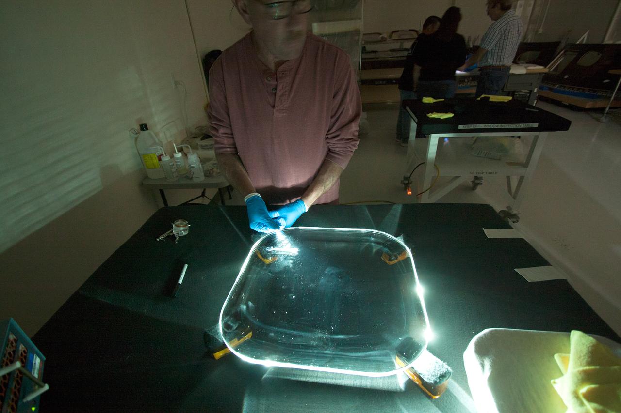 Inside the Neil Armstrong Operations and Checkout Building high bay at NASA's Kennedy Space Center in Florida, technicians remove a side thermal window from one of Orion's tile panels on May 15, 2015. The tile panels with thermal windows intact were removed from Orion in the Launch Abort System Facility after the Exploration Flight Test-1 (EFT-1) spacecraft returned to Kennedy in late December. All of the windows are being removed and disassembled for post-flight inspection for any signs of micrometeoroid or orbital debris impacts or other potential glass damage. Part of Batch image transfer from Flickr.