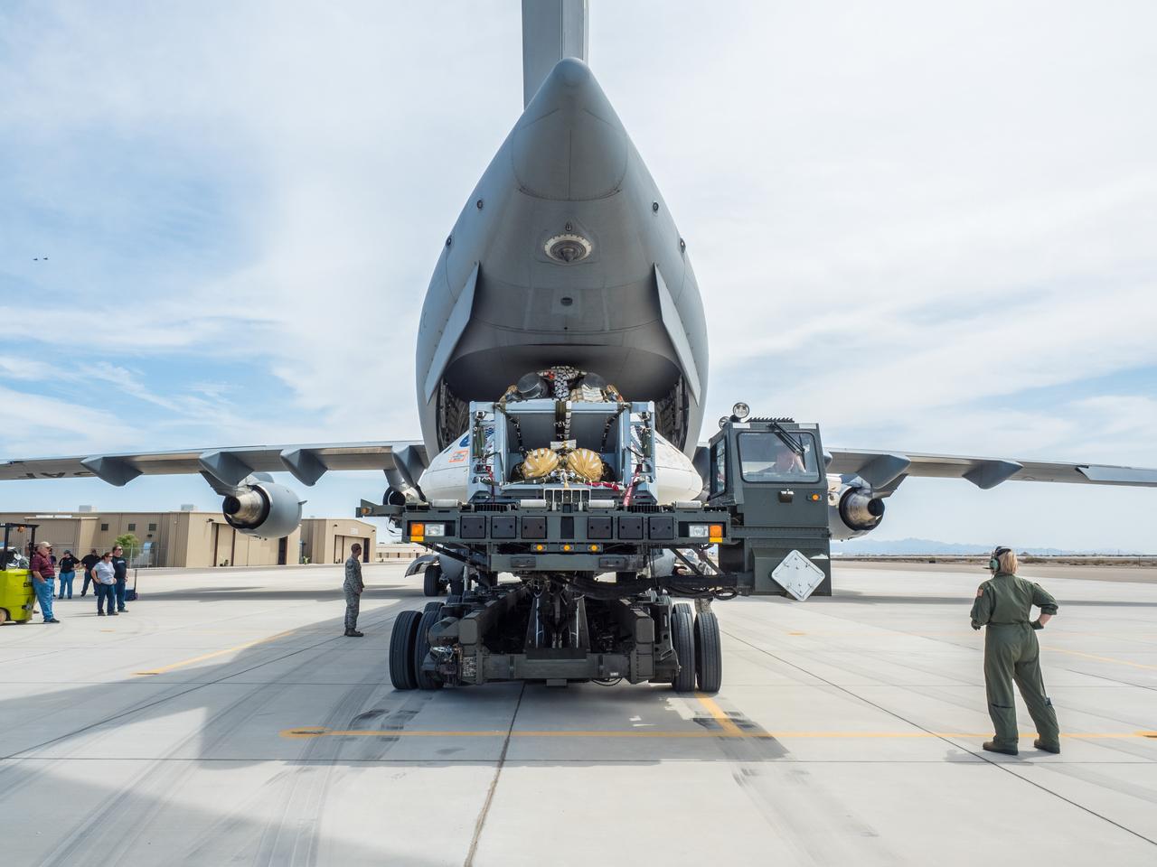 Engineers prepare to test the parachute system for NASA’s Orion spacecraft at the U.S. Army Yuma Proving Ground in Yuma, Arizona on Aug. 24, 2015. During the test, planned for Wednesday, Aug. 26, a C-17 aircraft will carry a representative Orion capsule to 35,000 feet in altitude and then drop it from its cargo bay. Engineers will test a scenario in which one of Orion’s two drogue parachutes, used to stabilize it in the air, does not deploy, and one of its three main parachutes, used to slow the capsule during the final stage of descent, also does not deploy. The risky test will provide data engineers will use as they gear up to qualify Orion’s parachutes for missions with astronauts. On Aug. 24, a C-17 was loaded with the test version of Orion, which has a similar mass and interfaces with the parachutes as the Orion being developed for deep space missions but is shorter on top to fit inside the aircraft. Part of Batch image transfer from Flickr.