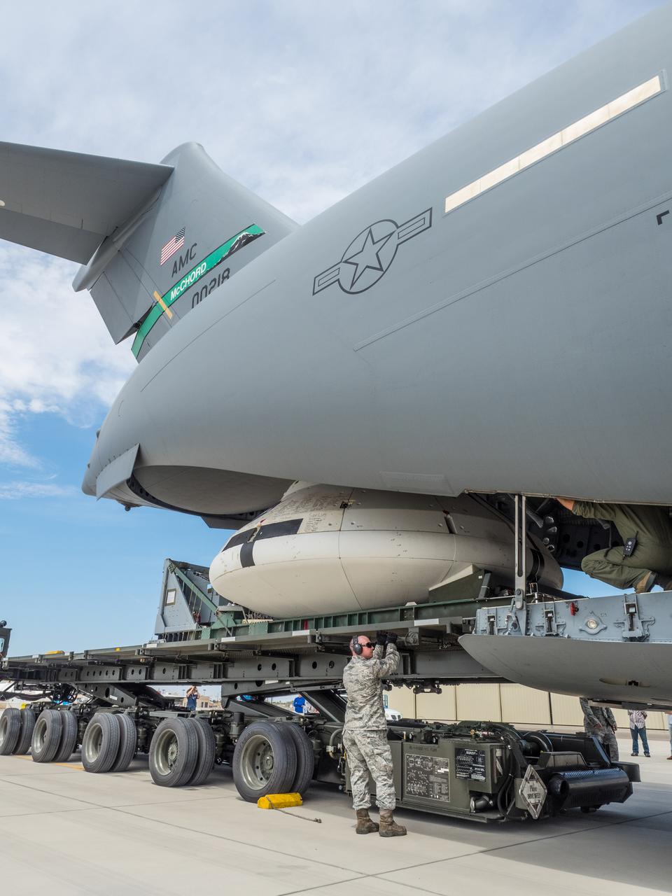 Engineers prepare to test the parachute system for NASA’s Orion spacecraft at the U.S. Army Yuma Proving Ground in Yuma, Arizona on Aug. 24, 2015. During the test, planned for Wednesday, Aug. 26, a C-17 aircraft will carry a representative Orion capsule to 35,000 feet in altitude and then drop it from its cargo bay. Engineers will test a scenario in which one of Orion’s two drogue parachutes, used to stabilize it in the air, does not deploy, and one of its three main parachutes, used to slow the capsule during the final stage of descent, also does not deploy. The risky test will provide data engineers will use as they gear up to qualify Orion’s parachutes for missions with astronauts. On Aug. 24, a C-17 was loaded with the test version of Orion, which has a similar mass and interfaces with the parachutes as the Orion being developed for deep space missions but is shorter on top to fit inside the aircraft. Part of Batch image transfer from Flickr.
