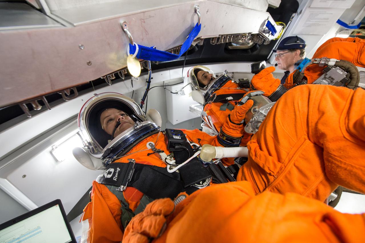 Engineers at NASA's Johnson Space Center in Houston evaluate how crews inside a mockup of the Orion spacecraft interact with the rotational hand controller and cursor control device while inside their Modified Advanced Crew Escape spacesuits on March 24, 2016. The controllers are used to operate Orion’s displays and control system, which the crew will use to maneuver and interact with the spacecraft during missions to deep space destinations. The testing aims to provide data that teams need to make sure astronauts who ride to space in Orion can appropriately interact with the control system while in their suits.