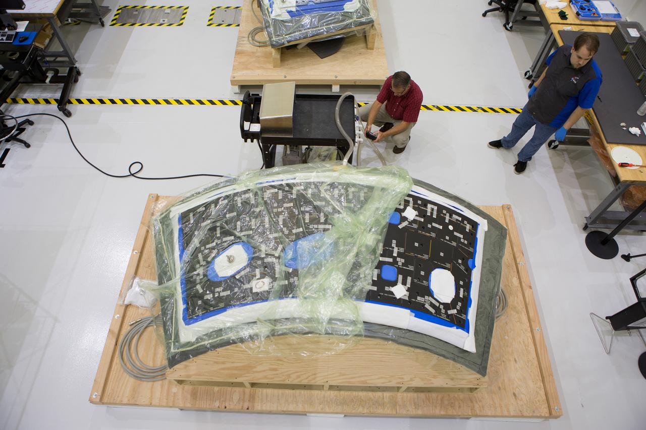 At Kennedy Space Center in Florida, technicians bond thermal protection system tiles to Orion's backshell panels on July 8, 2016...While similar to those used on the space shuttle, Orion only requires about 1,300 tiles compared to more than 24,000 on the shuttle. The tiles, along with the spacecraft’s heat shield, will protect Orion from the 5,000 degree Fahrenheit heat of re-entry.