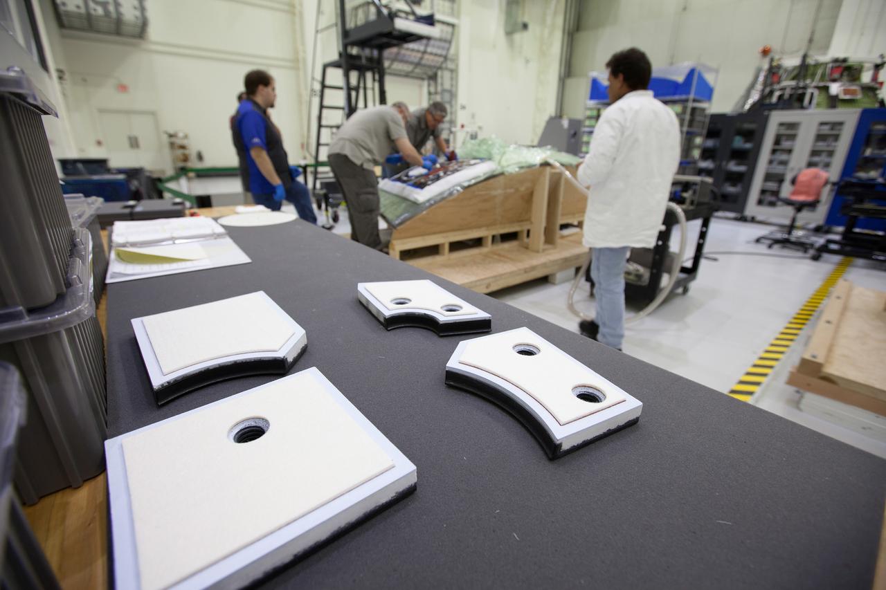 At Kennedy Space Center in Florida, technicians bond thermal protection system tiles to Orion's backshell panels on July 8, 2016...While similar to those used on the space shuttle, Orion only requires about 1,300 tiles compared to more than 24,000 on the shuttle. The tiles, along with the spacecraft’s heat shield, will protect Orion from the 5,000 degree Fahrenheit heat of re-entry.