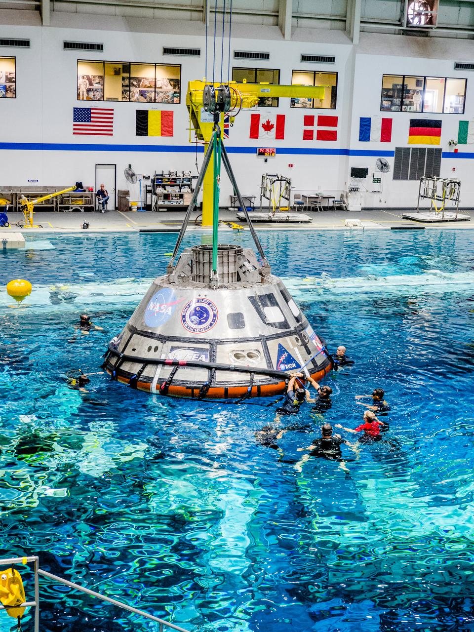 A group of U.S. Navy divers, Air Force pararescumen and Coast Guard rescue swimmers practice Orion underway recovery techniques this week in the Neutral Buoyancy Laboratory (NBL) at NASA’s Johnson Space Center in Houston on Sept. 21, 2016, to prepare for the first test flight of an uncrewed Orion spacecraft with the agency’s Space Launch System rocket during Artemis I. Part of Batch image transfer from Flickr.