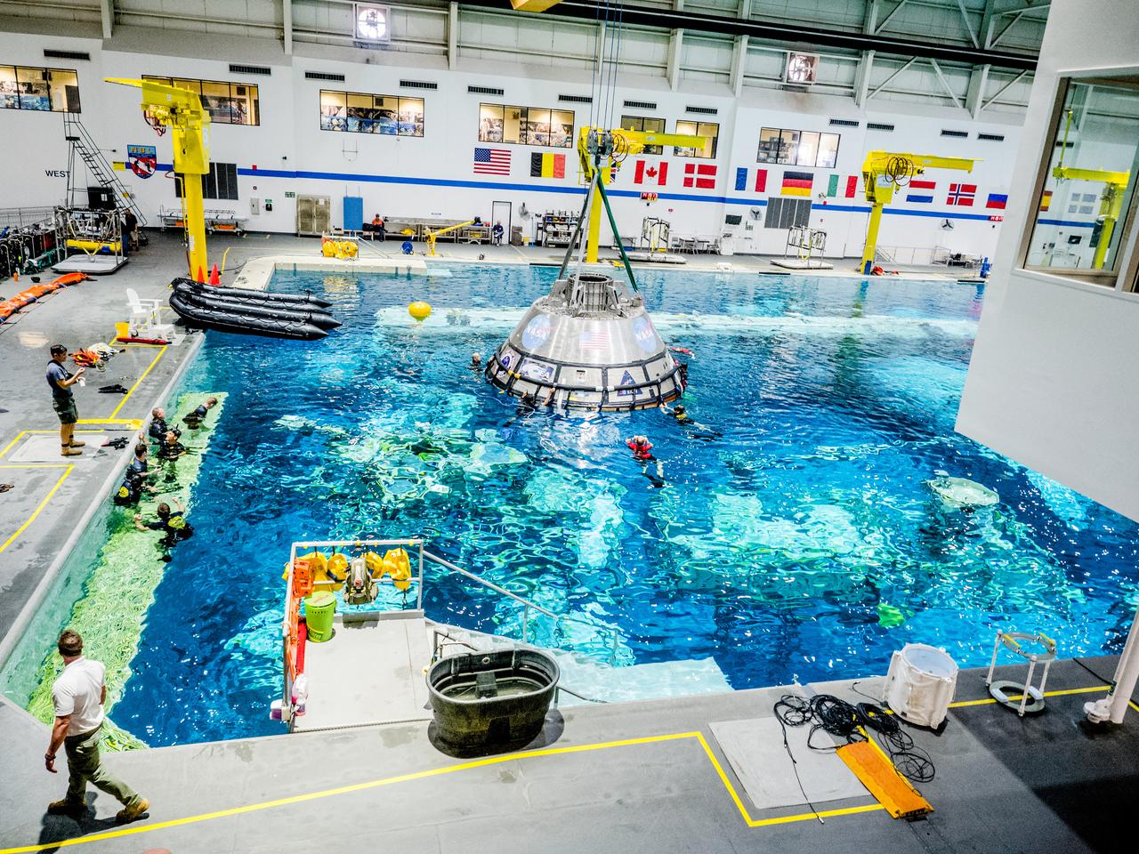 A group of U.S. Navy divers, Air Force pararescumen and Coast Guard rescue swimmers practice Orion underway recovery techniques this week in the Neutral Buoyancy Laboratory (NBL) at NASA’s Johnson Space Center in Houston on Sept. 21, 2016, to prepare for the first test flight of an uncrewed Orion spacecraft with the agency’s Space Launch System rocket during Artemis I. Part of Batch images transfer from Flickr.