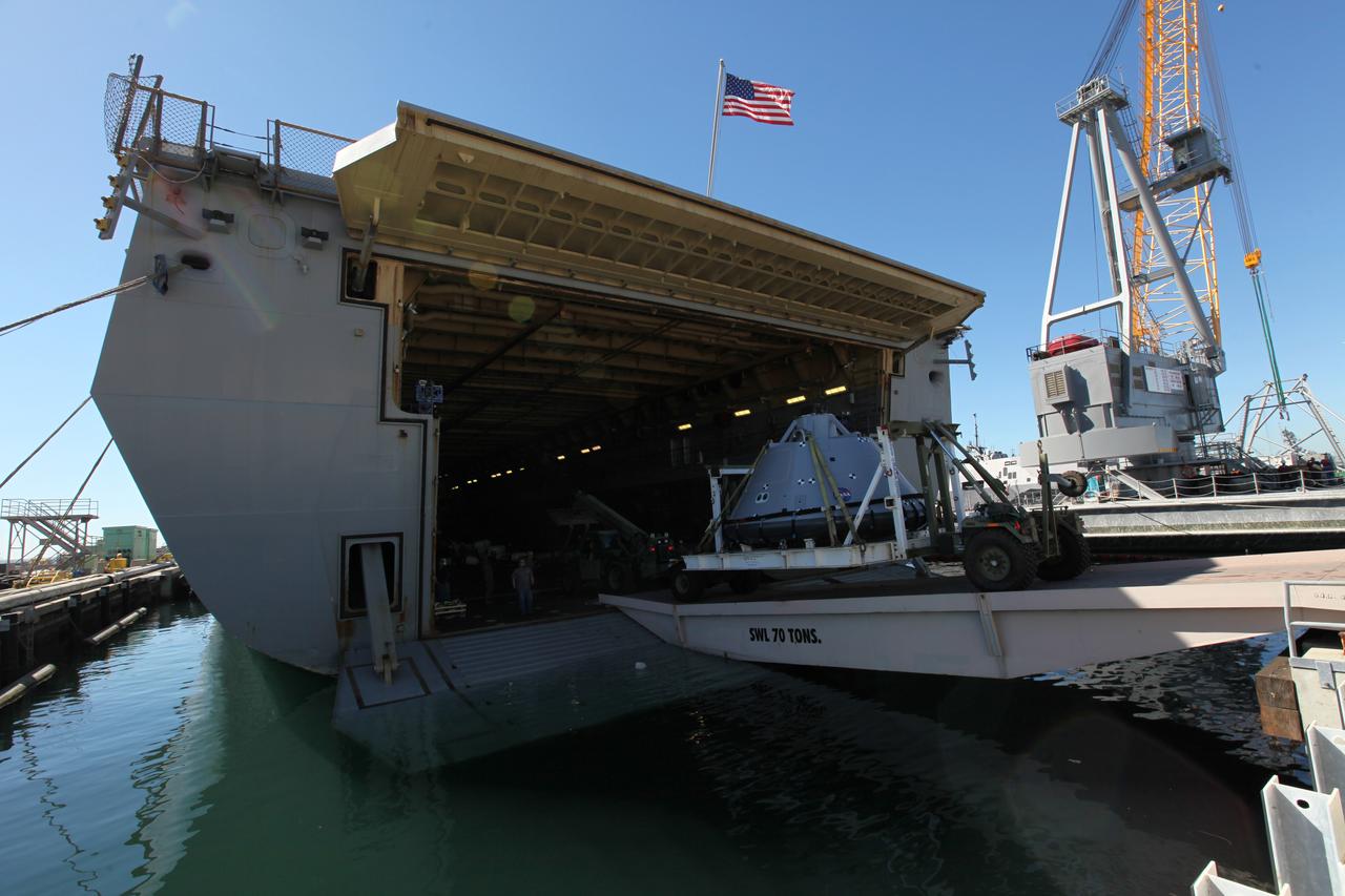 The test version of the Orion crew module is transported into the well deck of the USS San Diego at Naval Base San Diego in California on Oct. 21, 2016. NASA, Orion manufacturer Lockheed Martin and the U.S. Navy will head out to sea with the Orion test spacecraft aboard for Underway Recovery Test 5 (URT-5) in the Pacific Ocean off the coast of California. During URT-5, the team will demonstrate and evaluate the recovery processes, procedures, hardware and personnel necessary for recovery of Orion on its return from a deep space mission.
