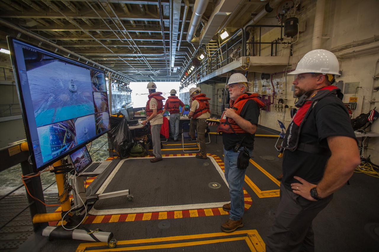 In the well deck of the USS San Diego, recovery team members monitor a portion of Underway Recovery Test 5 in the Pacific Ocean off the coast of California on Oct. 27, 2016. A test version of the Orion crew module is floating in open waters. NASA's Ground Systems Development and Operations Program and the U.S. Navy are conducting a series of tests using the ship's well deck, the test module, various watercraft and equipment to prepare for recovery of Orion on its return from deep space missions. The test will allow the team to demonstrate and evaluate recovery processes, procedures, hardware and personnel in open waters. Part of Batch images transfer from Flickr. 