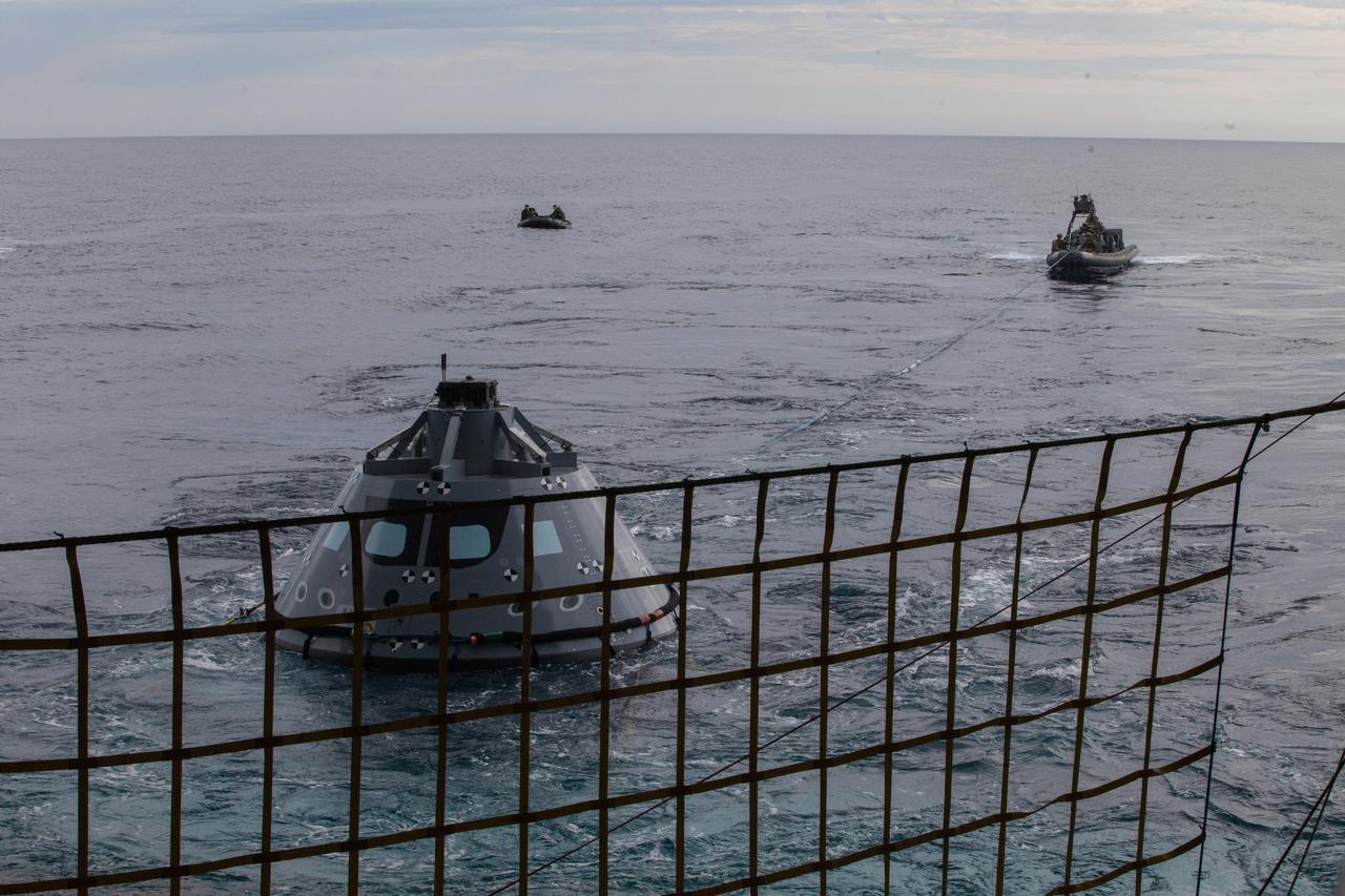 U.S. Navy divers and other personnel in a rigid hull inflatable boat are handling tether lines attached to a test version of the Orion crew module during Underway Recovery Test 5 in the Pacific Ocean off the coast of California. U.S. Navy divers in a smaller watercraft called a Zodiac boat are farther away. NASA's Ground Systems Development and Operations Program and the U.S. Navy are conducting a series of tests using the well deck of the USS San Diego, several watercraft and personnel to prepare for recovery of Orion on its return from deep space missions. The testing will allow the team to demonstrate and evaluate recovery processes, procedures, hardware and personnel in open waters. Part of Batch images transfer from Flickr. 