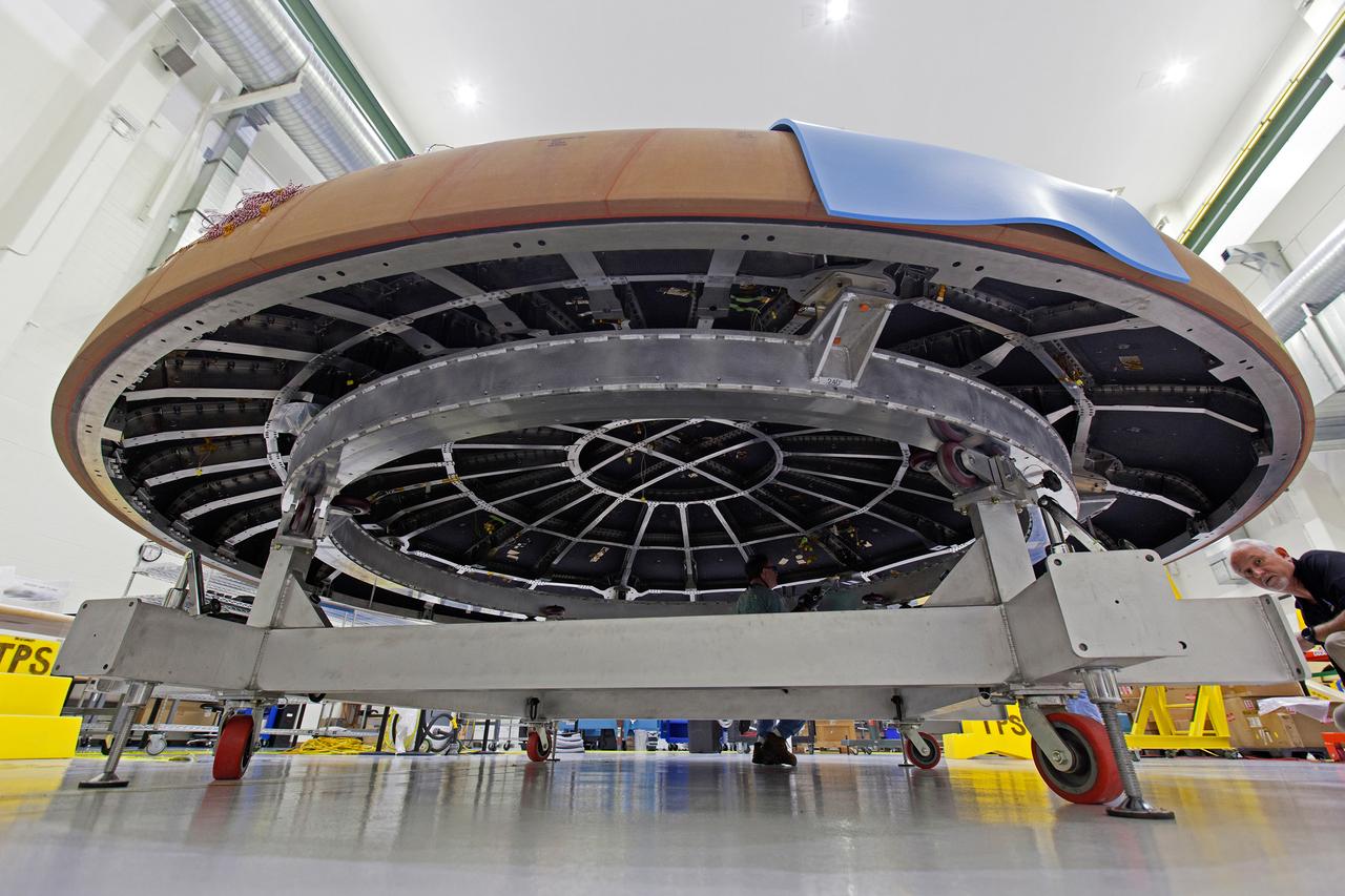 The Orion heat shield for Artemis I is being prepared for its move to the thermal chamber in the Neil Armstrong Operations and Checkout Building high bay at NASA's Kennedy Space Center in Florida on Oct. 23, 2017. Protective pads are being attached to the heat shield surface. The heat shield will undergo a thermal cycle test to verify acceptable workmanship and material quality. The test also serves to verify the heat shield's thermal protection systems have been manufactured and assembled correctly. The Orion spacecraft will launch atop NASA's Space Launch System rocket on its first uncrewed integrated flight.