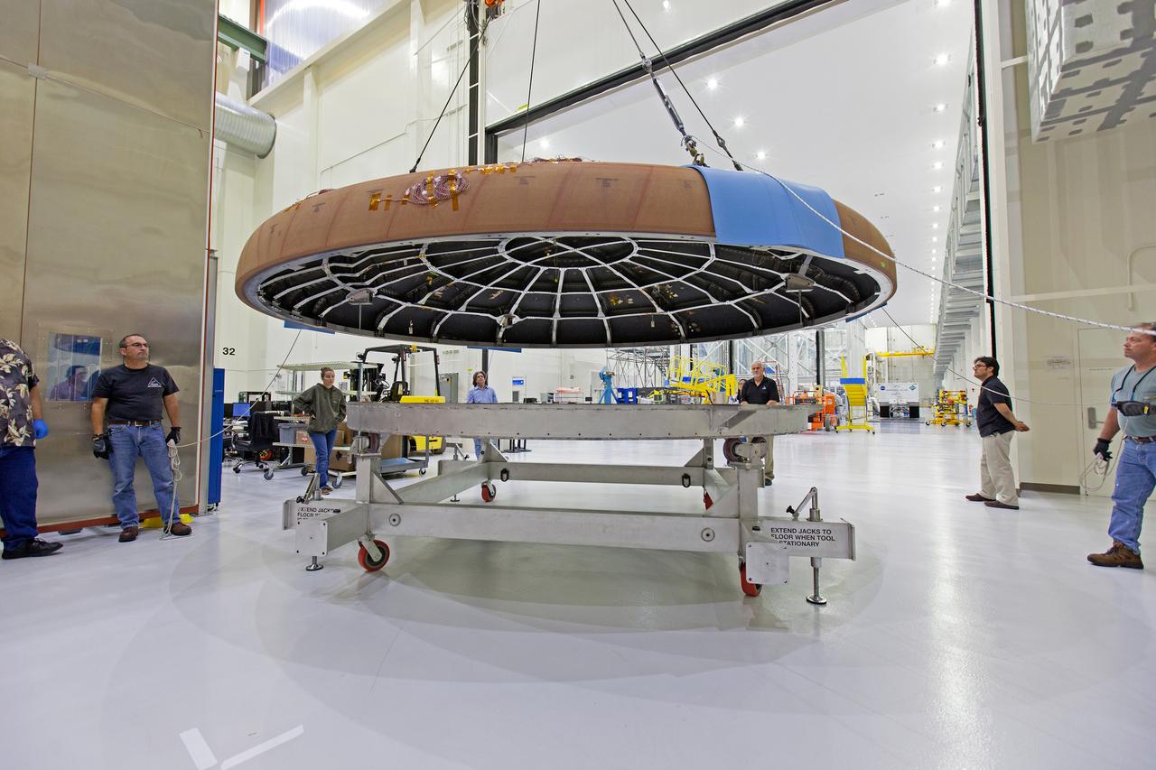 A crane attached to the Orion heat shield for Artemis I moves it toward the thermal chamber in the Neil Armstrong Operations and Checkout Building high bay at NASA's Kennedy Space Center in Florida on Oct. 23, 2017. Protective pads were attached to the heat shield surface. The heat shield will undergo a thermal cycle test to verify acceptable workmanship and material quality. The test also serves to verify the heat shield's thermal protection systems have been manufactured and assembled correctly. The Orion spacecraft will launch atop NASA's Space Launch System rocket on it first uncrewed integrated flight.
