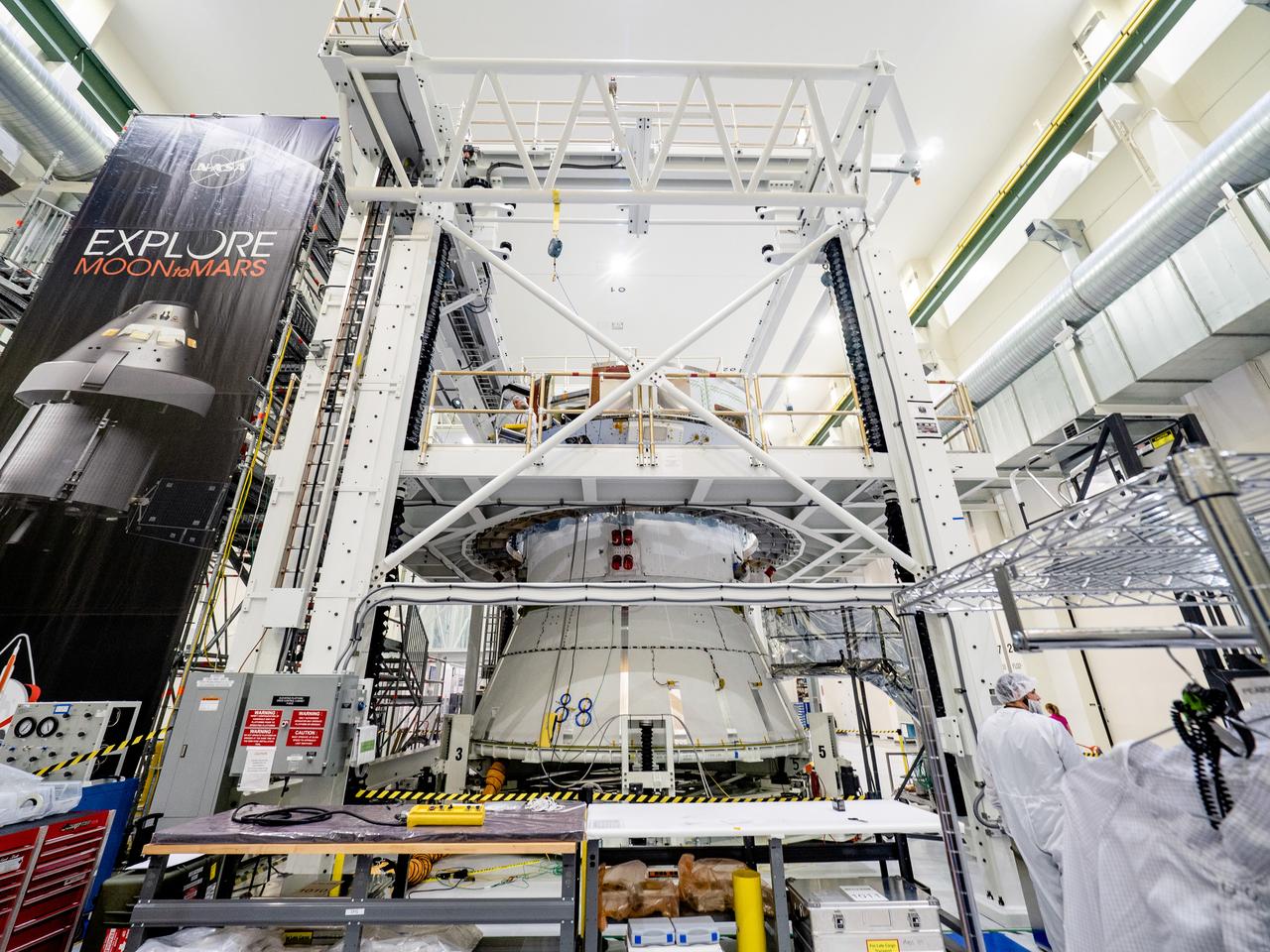 On April 29, Orion’s service module, shown here on May 2, 2019, moved to the lift station inside the assembly bay for installation and fastening of systems in preparation for Direct Field Acoustics Test (DFAT). The service module will move down to the east end of the bay next week where it will be surrounded with speakers and exposed to the acoustic level that will be experienced in space.