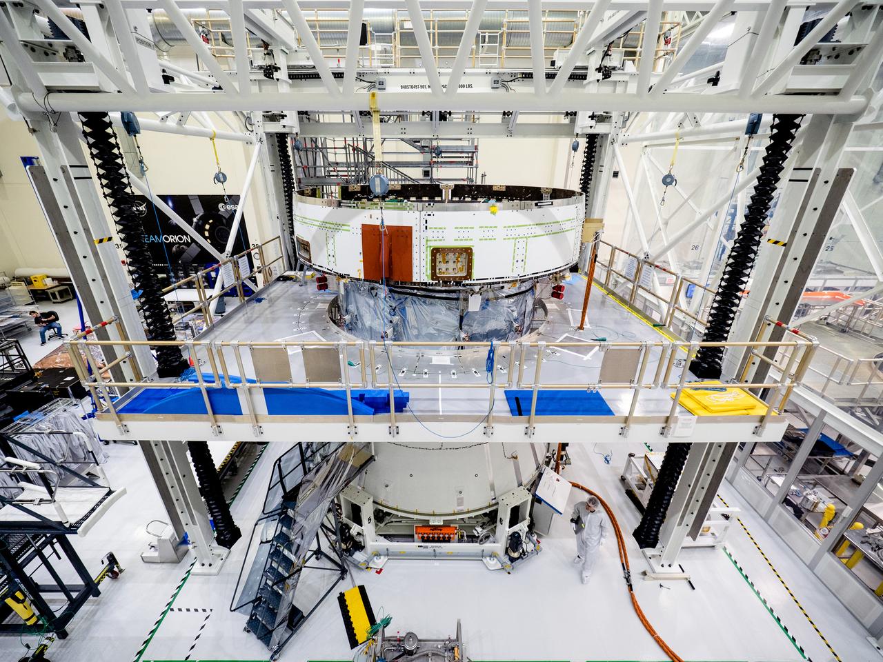 On April 29, Orion’s service module, shown here on May 2, 2019, moved to the lift station inside the assembly bay for installation and fastening of systems in preparation for Direct Field Acoustics Test (DFAT). The service module will move down to the east end of the bay next week where it will be surrounded with speakers and exposed to the acoustic level that will be experienced in space.