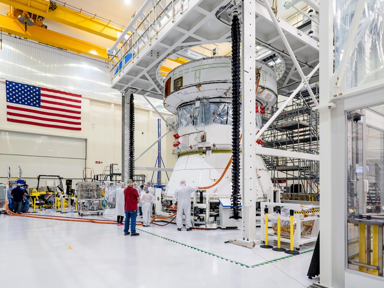 On April 29, Orion’s Service Module, shown here on May 3, 2019, moved to the lift station inside the assembly bay for installation and fastening of systems in preparation for Direct Field Acoustics Test (DFAT). The Service Module will move down to the east end of the bay next week where it will be surrounded with speakers and exposed to the acoustic level that will be experienced in space.