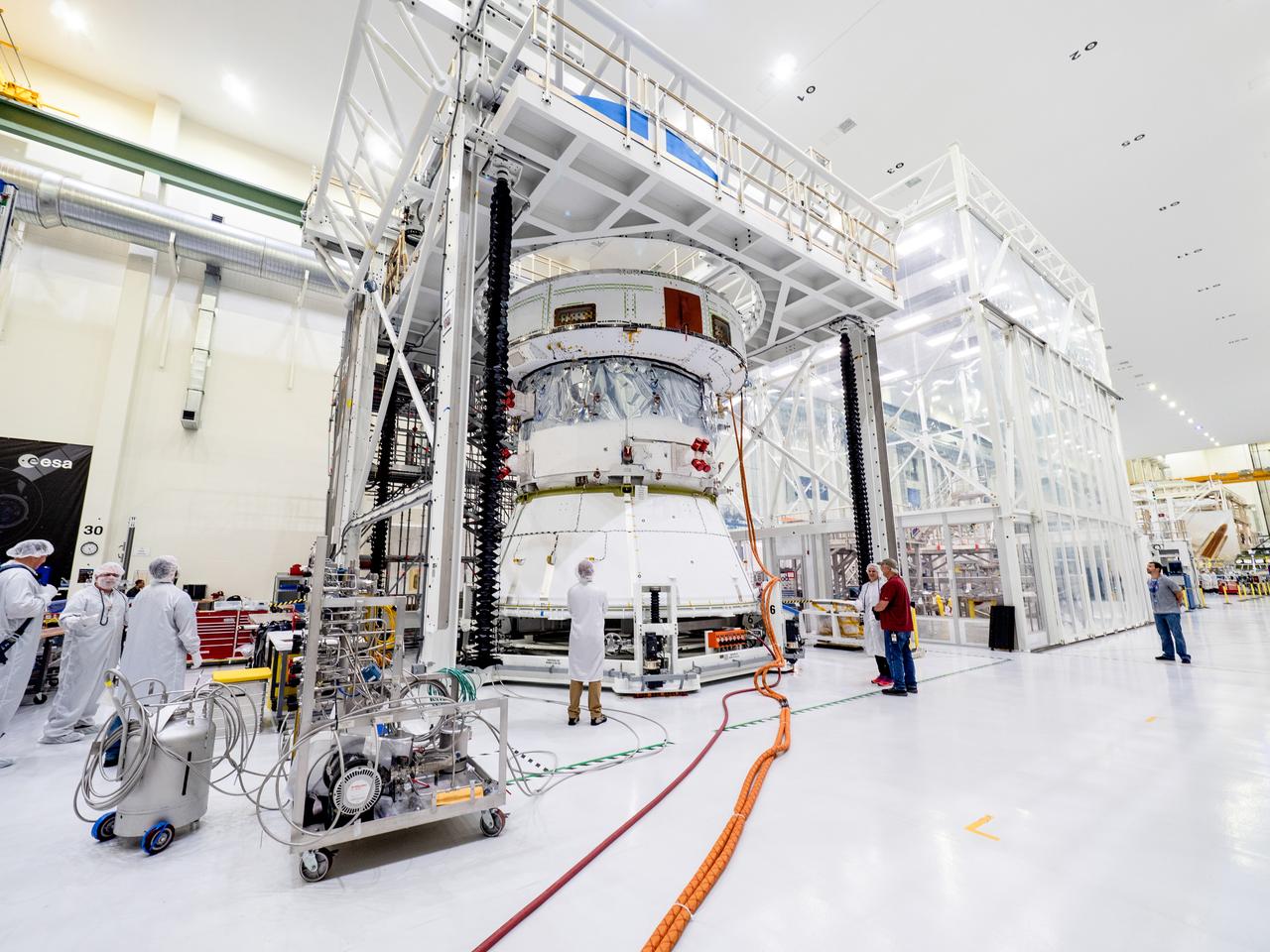 On April 29, Orion’s Service Module, shown here on May 3, 2019, moved to the lift station inside the assembly bay for installation and fastening of systems in preparation for Direct Field Acoustics Test (DFAT). The Service Module will move down to the east end of the bay next week where it will be surrounded with speakers and exposed to the acoustic level that will be experienced in space.