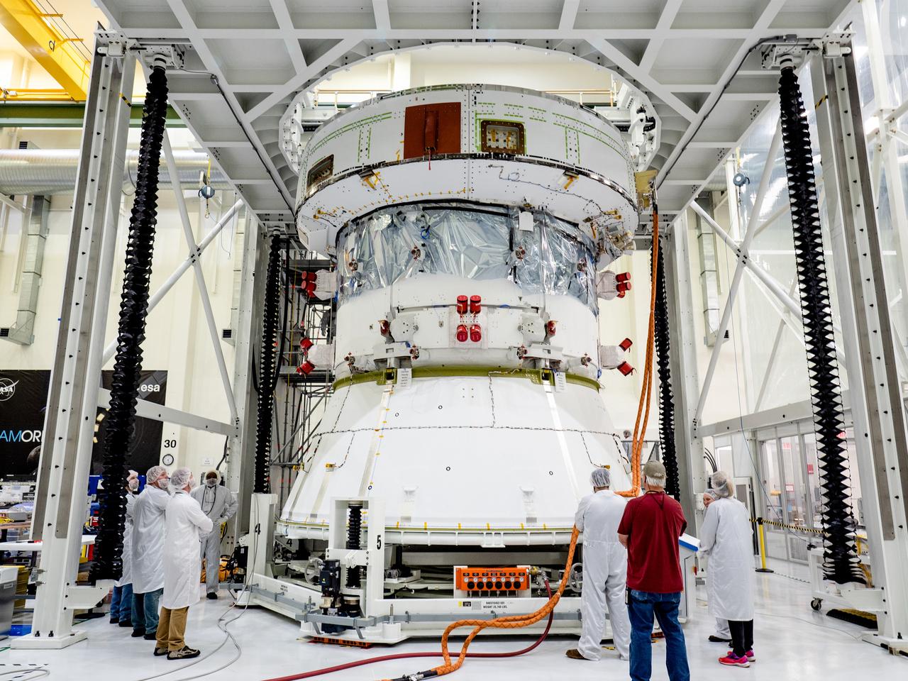 On April 29, Orion’s Service Module, shown here on May 3, 2019, moved to the lift station inside the assembly bay for installation and fastening of systems in preparation for Direct Field Acoustics Test (DFAT). The Service Module will move down to the east end of the bay next week where it will be surrounded with speakers and exposed to the acoustic level that will be experienced in space.