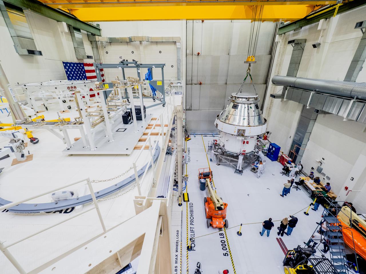 The Orion crew and service module stack for Artemis I was lifted out of the Final Assembly and Test (FAST) cell on November 11, 2019. The spacecraft has been stationed in the FAST cell since July for mating and closeout processing. The service module and crew module were moved separately into the cell, stacked and connected together for the mission. After lifting out of the cell, Orion will be attached to a tool called a verticator that rotates the stack from its vertical configuration to a horizontal configuration for transport to NASA’s Plum Brook Station in Sandusky, Ohio, where it will undergo full environmental testing to certify the complete vehicle for flight. Once the vehicle returns to Kennedy in several months, it will return to the FAST cell for installation of final panels left off for environmental testing purposes and the service module’s four solar arrays.