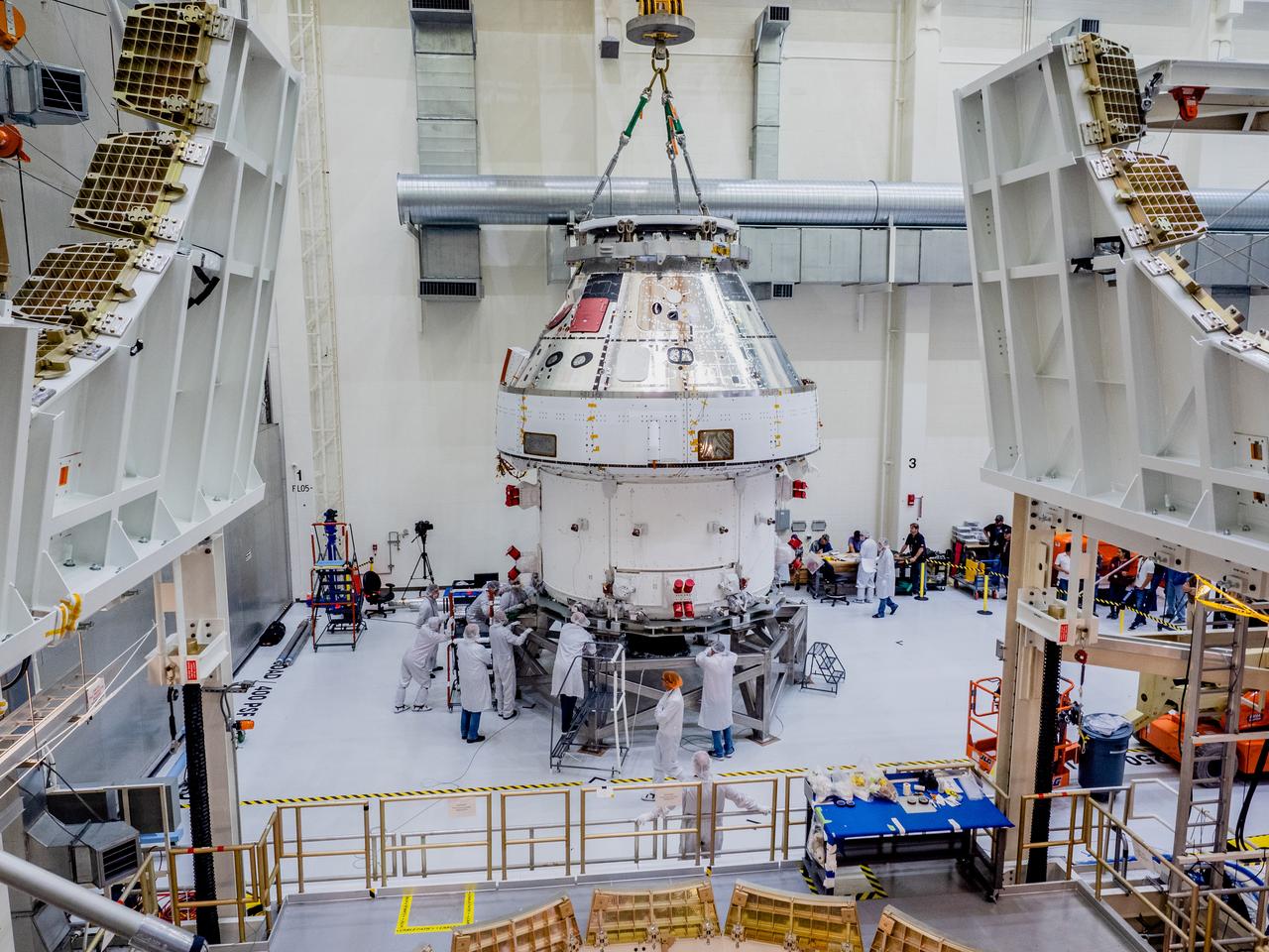 The Orion crew and service module stack for Artemis I was lifted out of the Final Assembly and Test (FAST) cell on November 11, 2019. The spacecraft has been stationed in the FAST cell since July for mating and closeout processing. The service module and crew module were moved separately into the cell, stacked and connected together for the mission. After lifting out of the cell, Orion will be attached to a tool called a verticator that rotates the stack from its vertical configuration to a horizontal configuration for transport to NASA’s Plum Brook Station in Sandusky, Ohio, where it will undergo full environmental testing to certify the complete vehicle for flight. Once the vehicle returns to Kennedy in several months, it will return to the FAST cell for installation of final panels left off for environmental testing purposes and the service module’s four solar arrays.