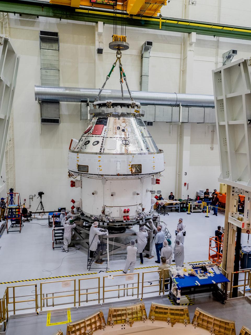 The Orion crew and service module stack for Artemis I was lifted out of the Final Assembly and Test (FAST) cell on November 11, 2019. The spacecraft has been stationed in the FAST cell since July for mating and closeout processing. The service module and crew module were moved separately into the cell, stacked and connected together for the mission. After lifting out of the cell, Orion will be attached to a tool called a verticator that rotates the stack from its vertical configuration to a horizontal configuration for transport to NASA’s Plum Brook Station in Sandusky, Ohio, where it will undergo full environmental testing to certify the complete vehicle for flight. Once the vehicle returns to Kennedy in several months, it will return to the FAST cell for installation of final panels left off for environmental testing purposes and the service module’s four solar arrays.